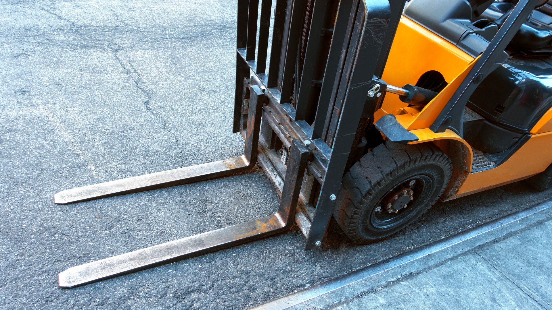 close up of fork lift blades on an urban city street